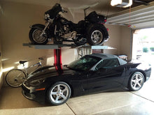 Load image into Gallery viewer, Single-post vehicle lift holding a motorcycle above a Corvette in a residential garage
