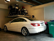Load image into Gallery viewer, Single-post vehicle lift holding both a motorcycle and a moped over a Mercedes for extra space in a home garage
